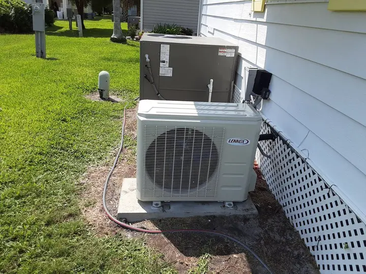 Mini-split heat pump condenser beside a house