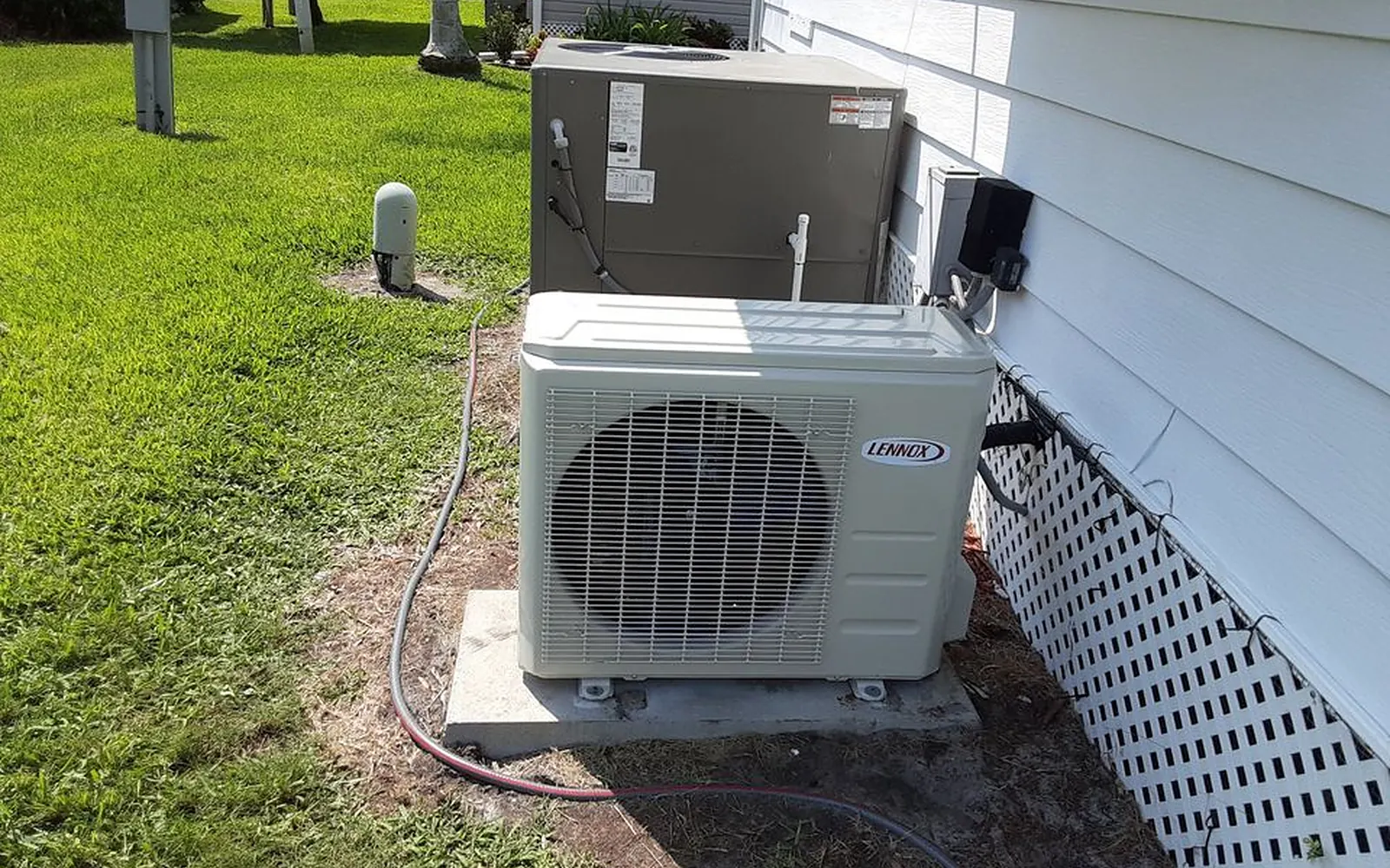 Heat pump condenser installed beside a home