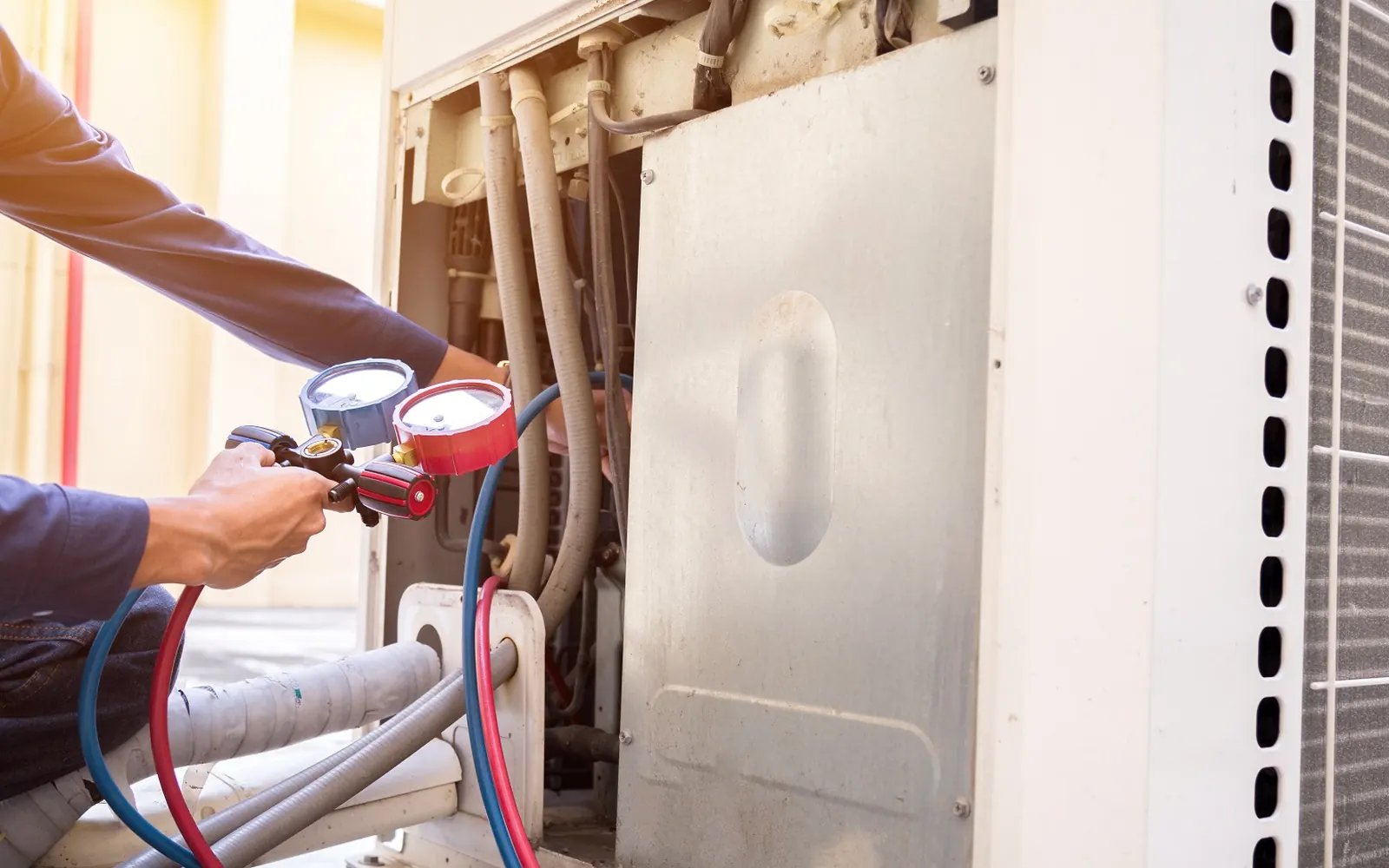 Technician checking gauges on a residential air conditioning unit