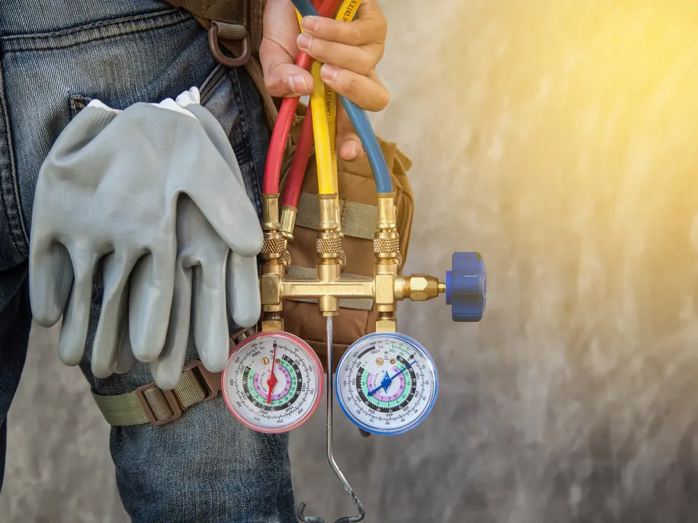 Technician holding refrigerant gauges