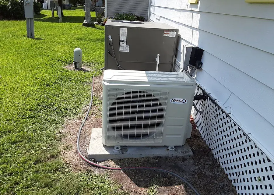 Heat pump condenser installed beside a home