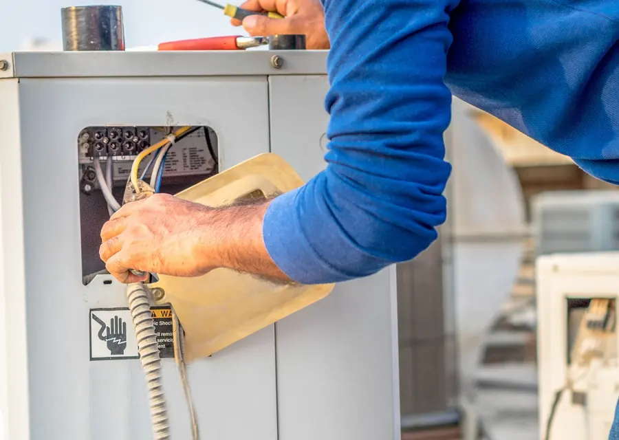 Technician checking refrigerant pressures on a condenser